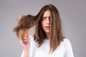 Kobieta rozczesuje suche włosy